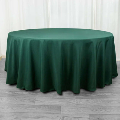 Round green tablecloth on a wooden floor.