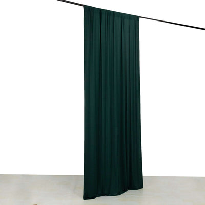 Dark green fabric curtain hanging on a rod against a white background