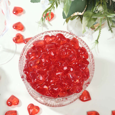 Red heart-shaped candies in a crystal bowl, surrounded by smaller hearts.