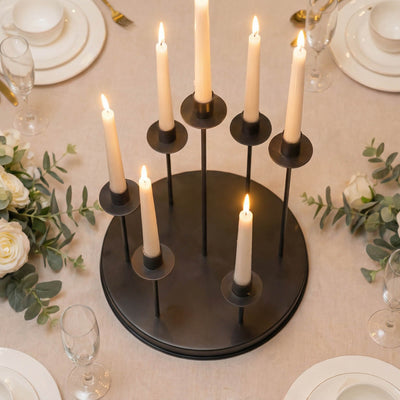 Black candelabra centerpiece with lit taper candles on an elegant wedding table
