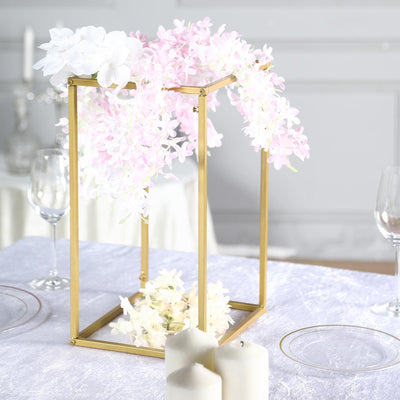 Elegant floral centerpiece in gold frame with pink and white flowers.