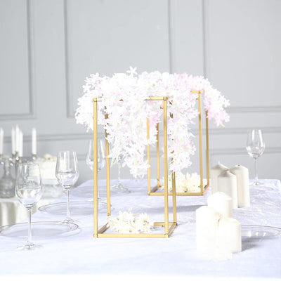 Elegant floral centerpieces in gold frames on a dining table setting.
