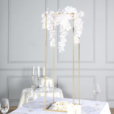 Elegant gold wedding centerpiece with cascading white flowers and candles.