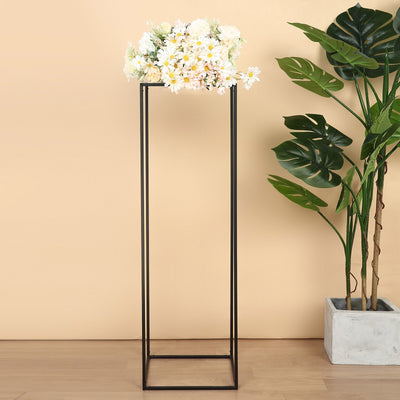 Modern black flower stand with white floral arrangement and greenery.