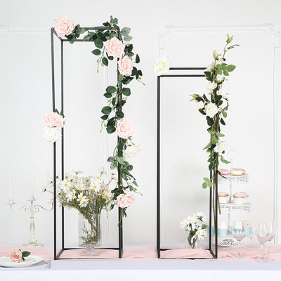 Floral arch stands with pink and white roses for event decoration.