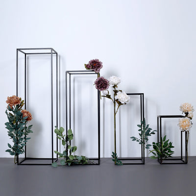 Decorative flower display with geometric metal frames and greenery.
