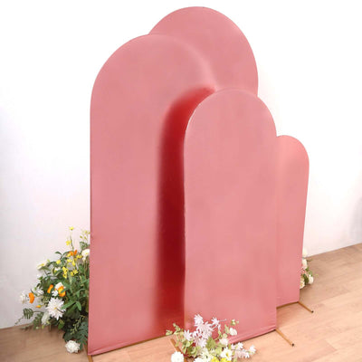 Three pink arch-shaped display boards with flowers in front.