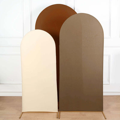 Three arched fabric panels in beige and brown on stands against a white wall.