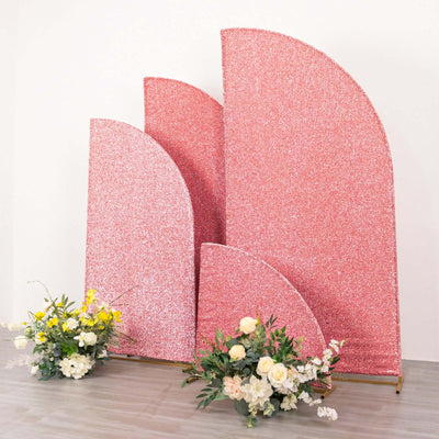 Pink glitter backdrop with curved shapes and floral arrangements.