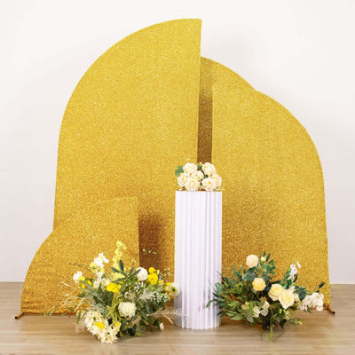 Gold glitter backdrop with floral arrangements and a white column.