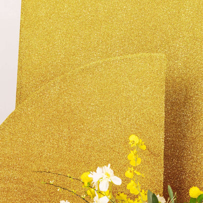 Gold glitter backdrop with floral accents for creative photography.