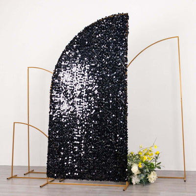 Black sequin backdrop with gold frame and floral arrangement at the base.