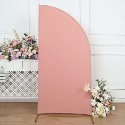 Curved pink backdrop with floral arrangement in a studio setting.