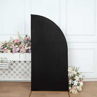 Black curved backdrop for photography with floral arrangement.