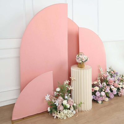 Pink curved backdrop with floral arrangement and pedestal table.