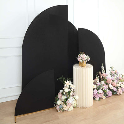 Black backdrop with floral arrangement and decorative table in a staged scene.