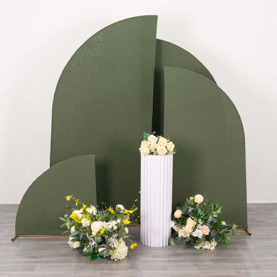 Green backdrop with floral arrangements and a white pedestal vase.