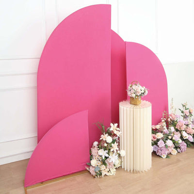 Pink backdrop with floral arrangements and a decorative table.