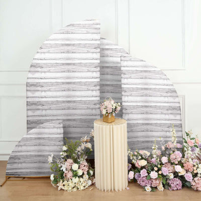 Decorative backdrop with floral arrangements and a pedestal table.
