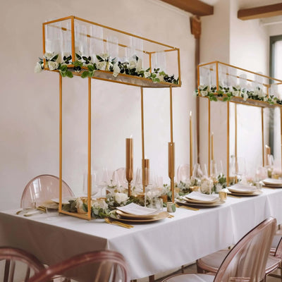 Elegant table setting with gold decor, floral arrangements, and glassware.