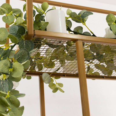 Decorative shelving unit with greenery and candles.