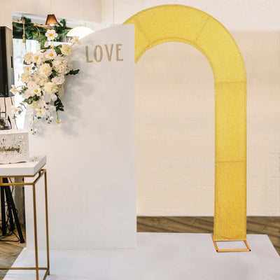 Gold glittered arch with "LOVE" sign for wedding decor setup.