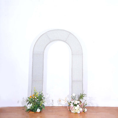 Textured arch backdrop with floral arrangements at the base