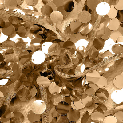 Gold sequins scattered on a fabric surface.