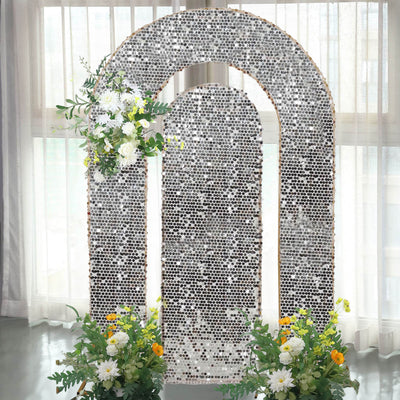 Silver arch backdrop with floral arrangements for events and celebrations.