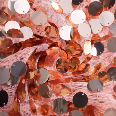 Rose gold sequins on pink tulle fabric for crafting and decoration.