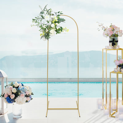 Gold flower arch with white and green floral arrangement by a poolside setting.