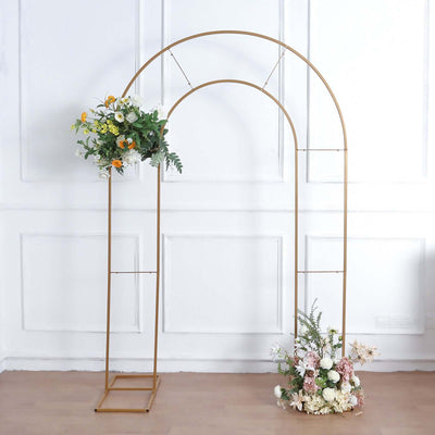 Gold arch frame with floral arrangements on a plain background.