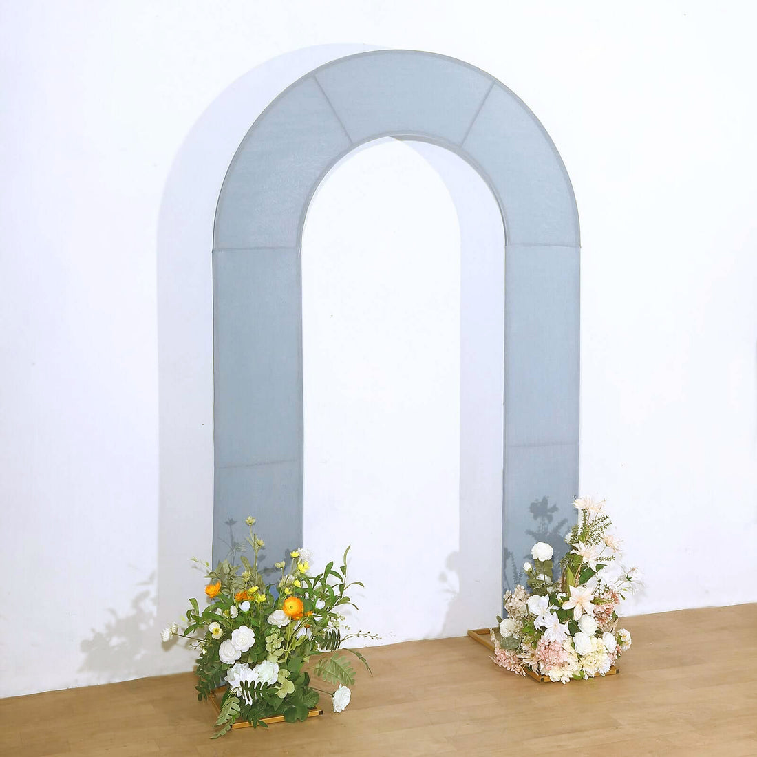 Gray arch backdrop with floral arrangements on either side.