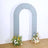Gray arch backdrop with floral arrangements on either side.