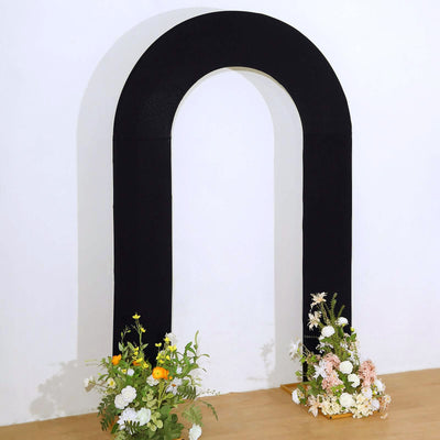 Black arch with floral arrangements at the base on a light wooden floor.