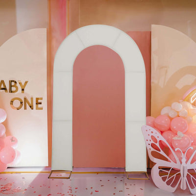 White arch backdrop for baby shower decorations with balloons and butterfly accents.