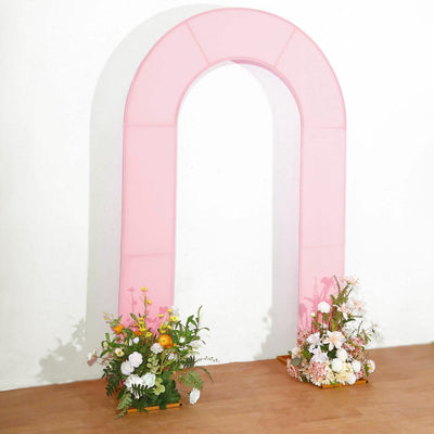 Pink arch backdrop with floral arrangements for events or photography.