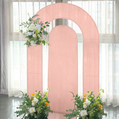 Pink arch backdrop with floral arrangements for events and photography.