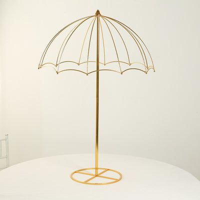 Gold decorative umbrella stand on a white table.