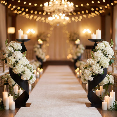 Elegant wedding aisle with candles, white flowers, and chandelier lighting