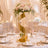 Luxury wedding table centerpiece with gold stand, pink roses, and white florals