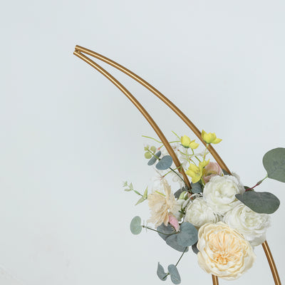 Gold arch with artificial flowers and greenery arrangement