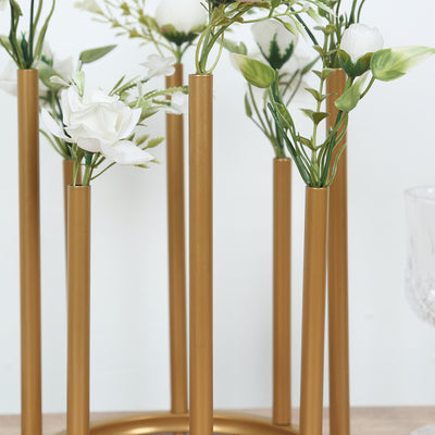 Gold flower vase holder with artificial white flowers.