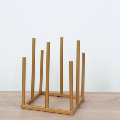 Gold metal plant stand with vertical rods on a wooden surface.
