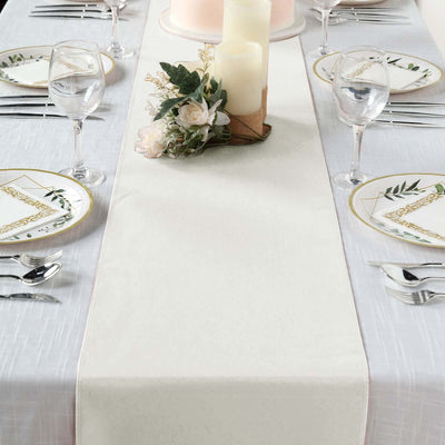 Elegant table setting with a neutral table runner and decorative candles.