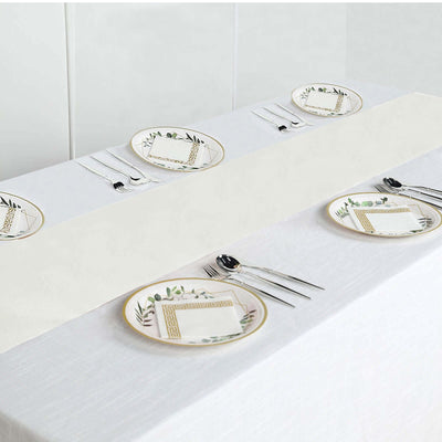 Elegant table setting with decorative plates and cutlery on a white tablecloth.