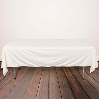 White tablecloth draped on a wooden table in a styled setting.