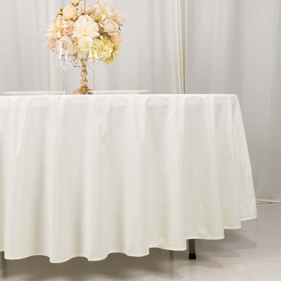 White tablecloth draped elegantly over a round table with floral centerpiece.