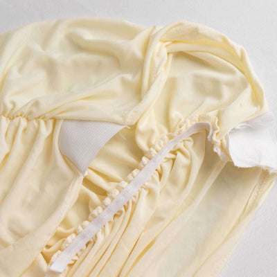 Yellow garment with gathered fabric and elastic details.