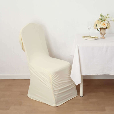 Cream chair cover draped over a chair beside an elegantly set table.